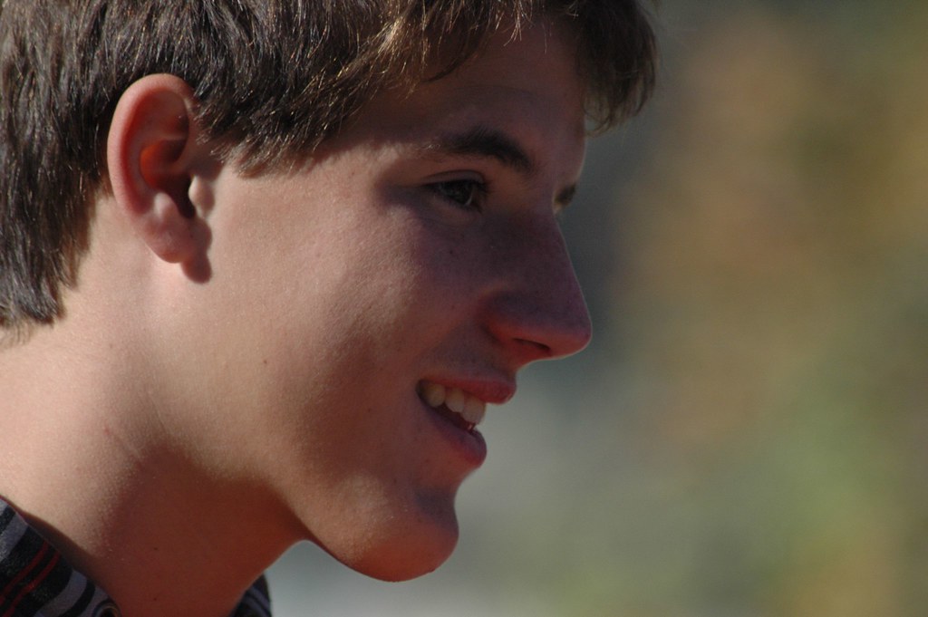 Primer plano de perfil de Marcos Pou sonriendo al aire libre